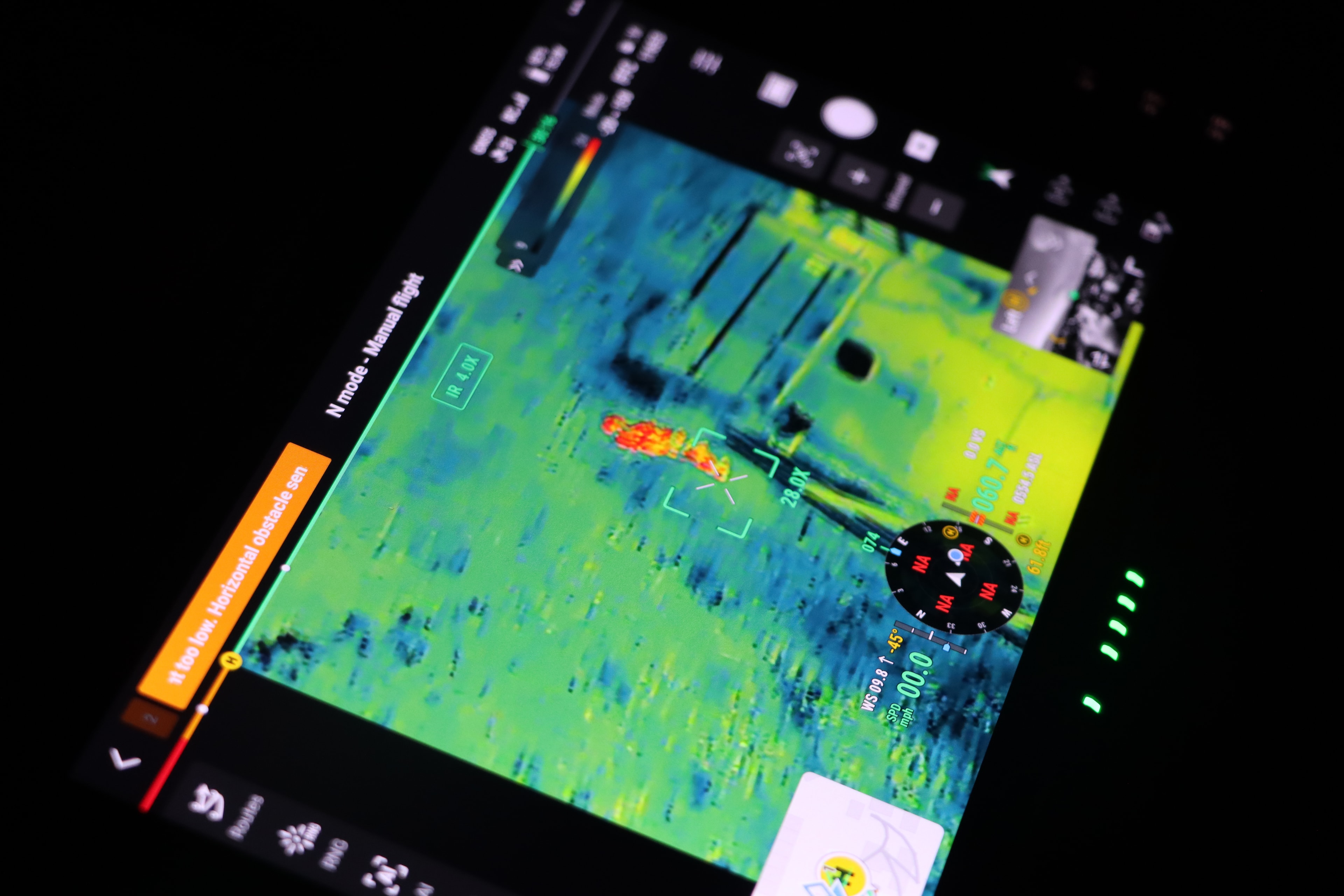 Green thermal drone feed showing a heat signature located on the ground